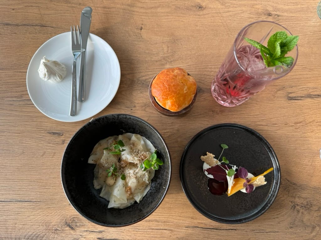 Four plates lay out various small dishes: the beginnings of a tasting menu